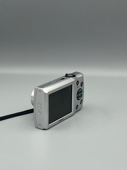 Angled rear view of a silver Canon PowerShot A2500 showing its LCD screen and side panel