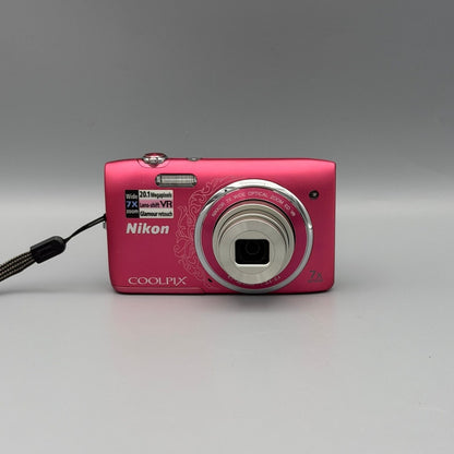 Front view of a pink Nikon Coolpix S3500 digital camera with its lens extended
