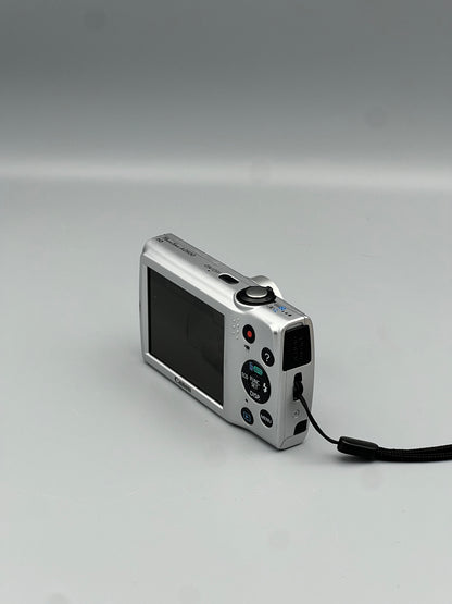 Silver Canon PowerShot A2500 viewed from the rear corner with its top controls and wrist strap visible