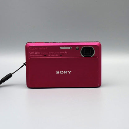 Front view of a pink Sony Cyber-shot DSC-TX9 showing the exposed lens and flash