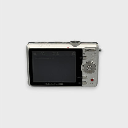 Rear view of a silver Kodak EasyShare M320 showing its LCD screen, circular control pad and red Share button