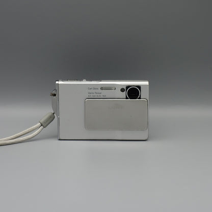 Front view of a silver Sony Cyber-shot DSC-T7 showing the exposed lens and flash