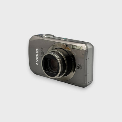 Front and side view of a silver Canon PowerShot SD4500 IS with its lens extended