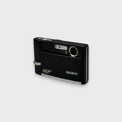 Black Sony Cyber-shot DSC-T50 viewed from the opposite front corner with its lens cover open and 007 logo visible