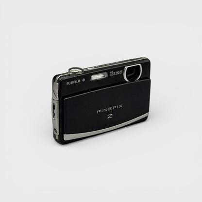 Angled front view of a black Fujifilm FinePix Z90 showing the exposed lens and top controls