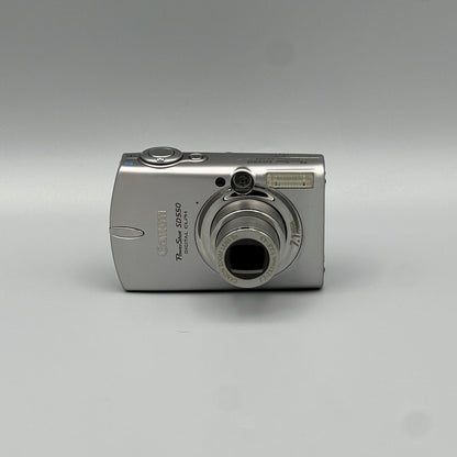 Silver Canon PowerShot SD550 front view with its lens extended.