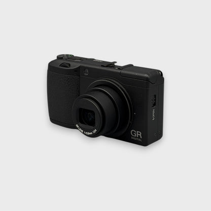 Front and side view of a black Ricoh GR Digital with its lens extended