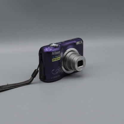 Purple Nikon Coolpix A10 viewed from a front angle showing the extended lens and grip.