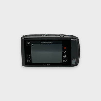 Rear view of a silver Canon PowerShot ELPH 500 HS showing its illuminated LCD touchscreen