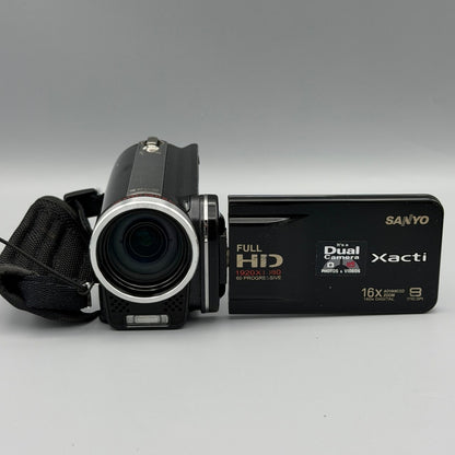 Front view of the black Sanyo Xacti VPC-FH1 camcorder with its lens and flip-out screen open