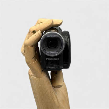 Black Panasonic SDR-S7P camcorder held in a wooden display hand, viewed from the front