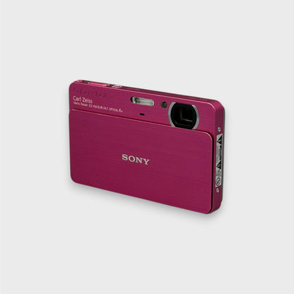 Pink Sony Cyber-shot DSC-T700 viewed from the opposite front corner with its lens cover open
