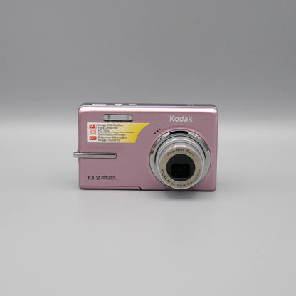 Pink Kodak EasyShare M1073 IS front view with its silver lens extended.
