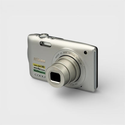 Front and side view of a silver Nikon Coolpix S3300 with its lens extended