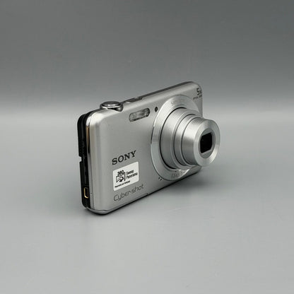 Silver Sony Cyber-shot DSC-W710 viewed from a front angle showing its extended lens and side panel.