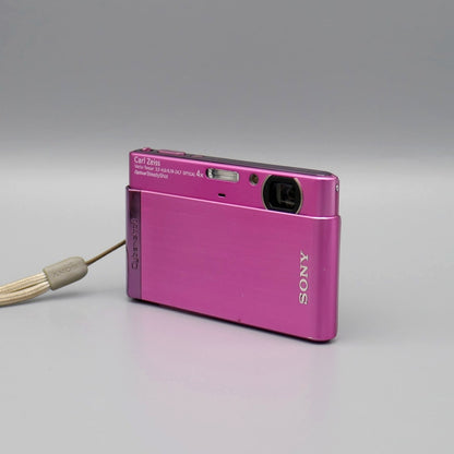 Front and side view of a pink Sony Cyber-shot DSC-T90 showing the exposed lens