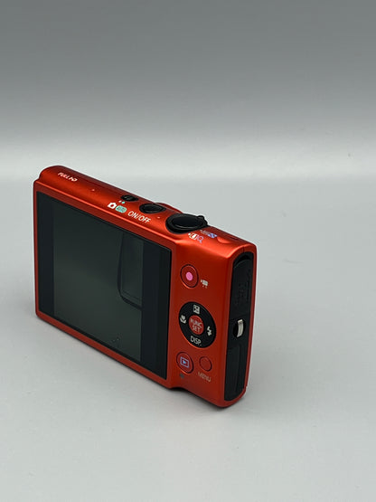 Rear corner view of a red Canon PowerShot ELPH 110 HS showing its screen, top buttons and black side panel