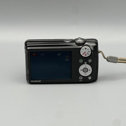 Rear view of a black Fujifilm FinePix F70EXR showing the LCD screen, mode dial and buttons