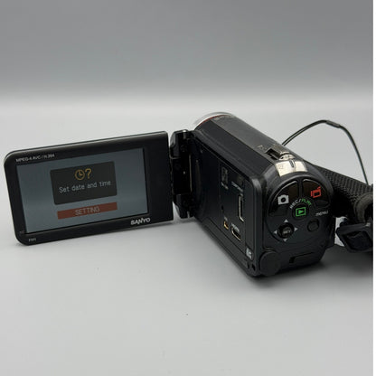 Rear view of the Sanyo Xacti VPC-FH1 camcorder with its screen showing the date and time setup