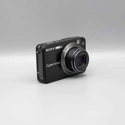 Angled front view of a black Sony Cyber-shot DSC-W170 showing its extended lens and slim side panel