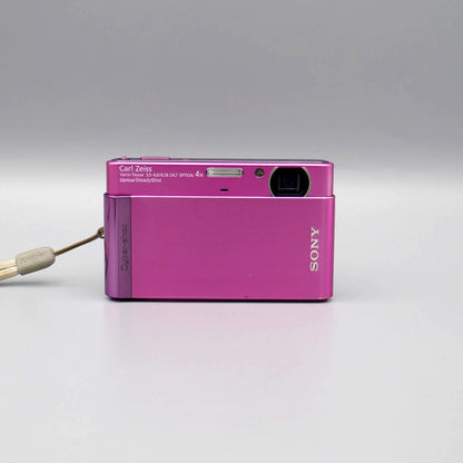 Front view of a pink Sony Cyber-shot DSC-T90 showing the exposed lens and flash