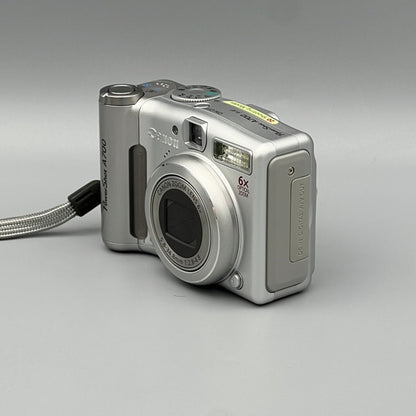 Angled view of a silver Canon PowerShot A700 showing the closed lens and side port cover