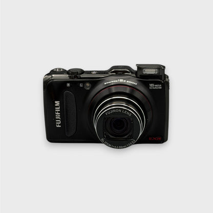Black Fujifilm FinePix F550EXR front view with its zoom lens extended and pop-up flash raised.