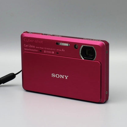 Front and side view of a pink Sony Cyber-shot DSC-TX9 showing the exposed lens