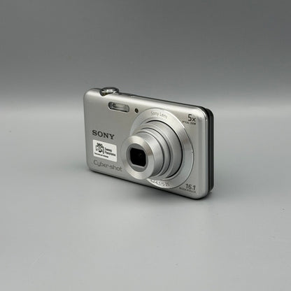 Silver Sony Cyber-shot DSC-W710 viewed from a front angle with its lens extended and top buttons visible.