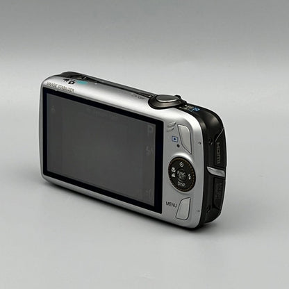 Rear corner view of a silver Canon PowerShot SD980 IS showing its wide LCD screen and circular control pad