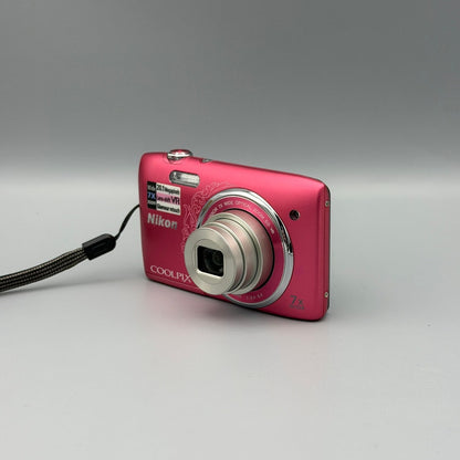 Front and side view of a pink Nikon Coolpix S3500 with its lens extended