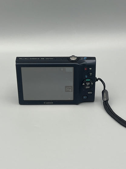 Rear view of a black Canon PowerShot A3400 IS showing the illuminated LCD screen and control buttons