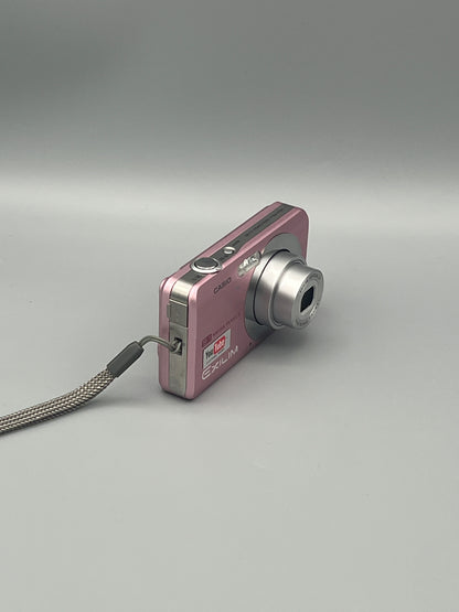 Pink Casio Exilim EX-Z85 viewed from a front angle showing the extended lens and side panel.