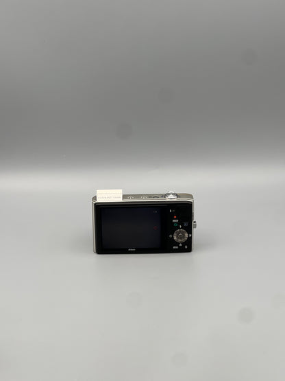 Rear view of a silver Nikon Coolpix S8000 showing its LCD screen, control dial and raised flash