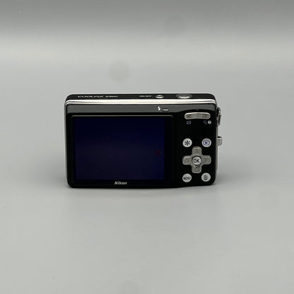 Rear view of a black Nikon Coolpix S560 showing its LCD screen and silver control buttons