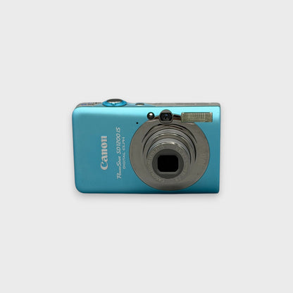 Front view of a blue Canon PowerShot SD1200 IS with its lens extended