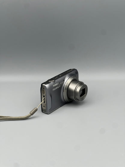 Angled front view of a silver Fujifilm FinePix T550 showing the extended lens and top controls