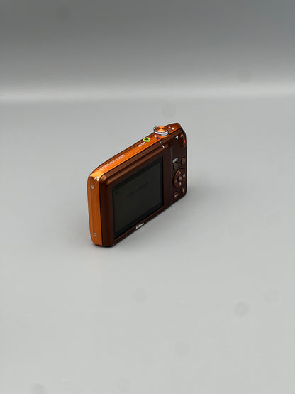Angled rear view of an orange Nikon Coolpix S3500 showing its LCD screen and control buttons