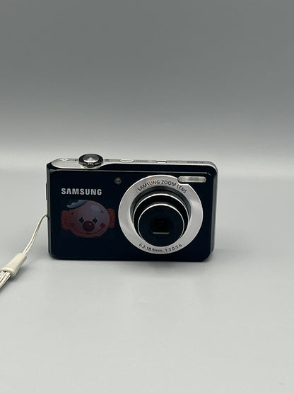 Front view of a black Samsung TL205 with the lens extended and a clown graphic on the front display