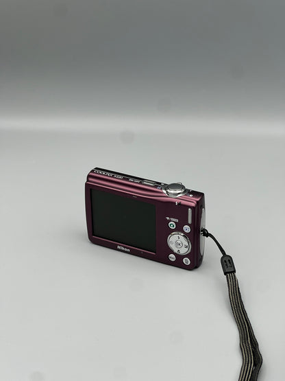Rear corner view of a plum Nikon Coolpix S220 showing its LCD screen, silver buttons and top controls