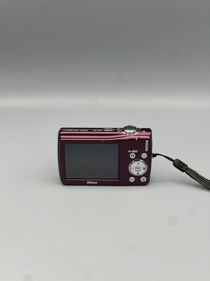 Rear view of a plum Nikon Coolpix S220 showing its LCD screen and silver control buttons