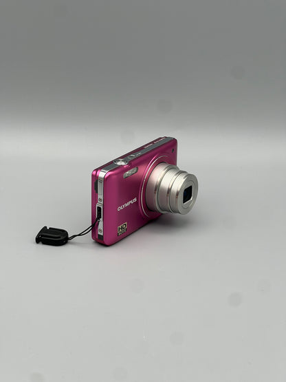 Angled front view of a pink Olympus VG-130 showing the extended lens and top controls