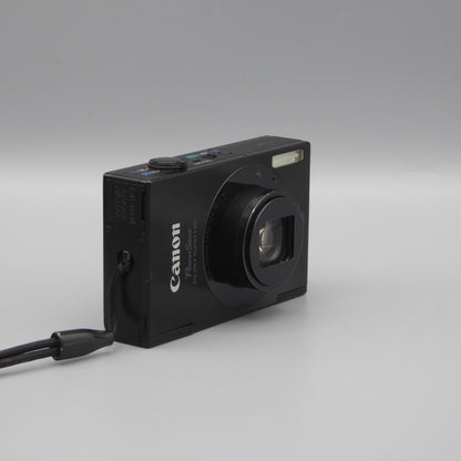 Black Canon PowerShot ELPH 520 HS viewed from a front angle showing its extended lens and side panel.