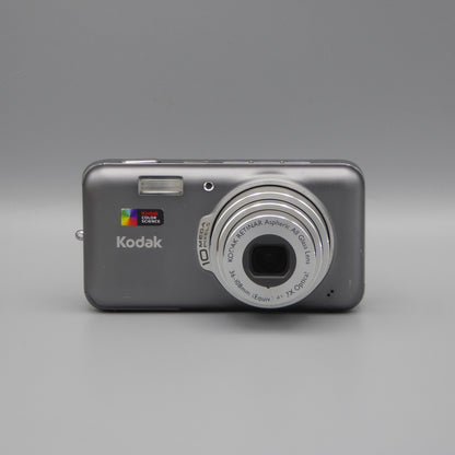 Front view of a gray Kodak EasyShare V1003 digital camera with its lens extended