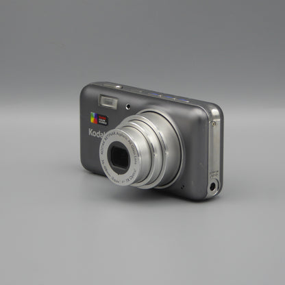 Front and side view of a gray Kodak EasyShare V1003 with its lens extended