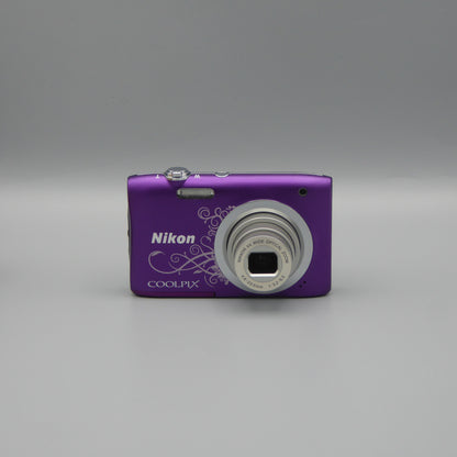 Front view of a purple Nikon Coolpix A100 with a white decorative pattern and extended lens