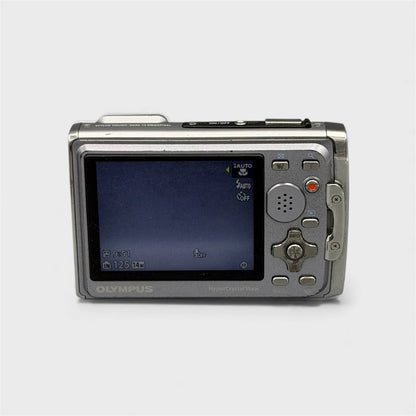 Rear view of a black and silver Olympus Tough 6020 showing the illuminated LCD screen and control buttons