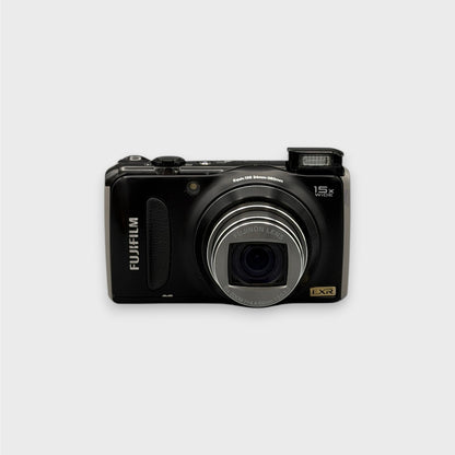 Black Fujifilm FinePix F300EXR front view with its zoom lens extended and pop-up flash raised.