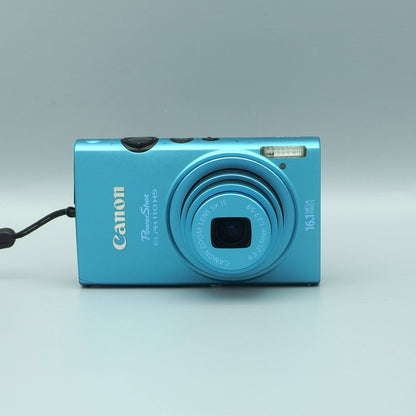 Front view of a blue Canon PowerShot ELPH 110 HS digital camera with its lens extended