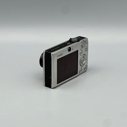 Silver Canon PowerShot SD770 IS viewed from the opposite rear corner with its screen and top controls visible
